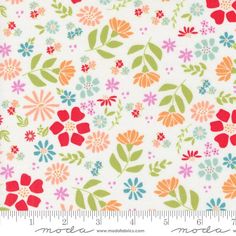 a white fabric with colorful flowers and leaves on the bottom, in front of a ruler