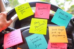 post - it notes on the steering wheel of a car with words written on them