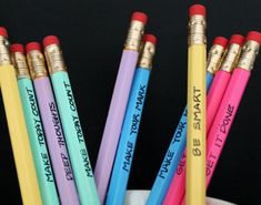 four colored pencils with writing on them