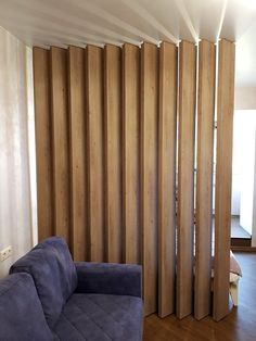 a living room filled with furniture and tall wooden slatted walls in front of a sliding glass door