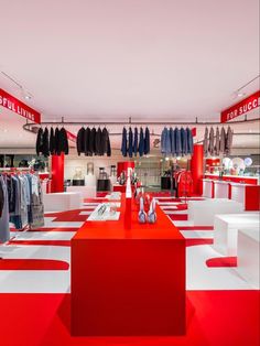 the inside of a clothing store with red and white flooring