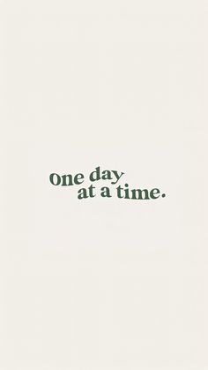 one day at a time is written in green ink on a white paper with black writing