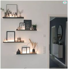 three shelves with pictures and candles on them in a room that is decorated with black and white decor