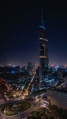 an aerial view of a city at night with the lights on and buildings lit up