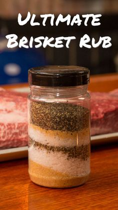 a jar filled with spices sitting on top of a wooden table next to steaks