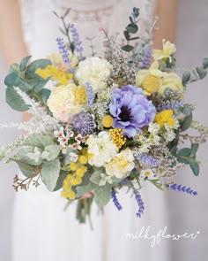 a bridal holding a bouquet of flowers and greenery