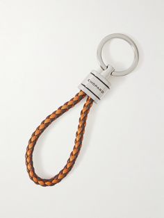 an orange and brown braided leather keychain with a metal hook on it