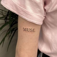 a woman's arm with the word muse tattooed on it