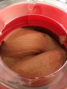 a red blender filled with brown liquid