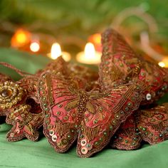 some red and gold decorations on a green cloth with lit candles in the back ground