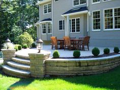 an outdoor patio with steps leading up to the dining room table and chairs on it