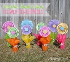 colorful paper flowers in front of a fence with the words cheerful cheap and easy flower centerpieces