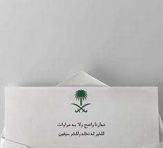 an open envelope with arabic writing and palm trees on the front, against a gray background