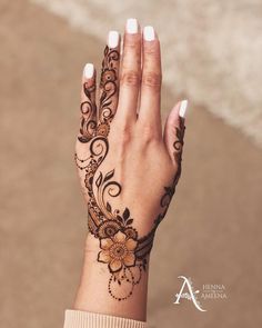 a woman's hand with henna tattoos on it