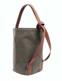 a gray bag with brown straps on the front and side, sitting against a white background