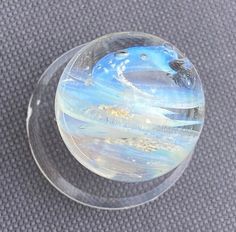 a clear glass object sitting on top of a gray carpeted floor next to a wall