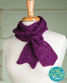 a purple knitted scarf sitting on top of a white mannequin