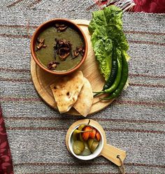 a bowl of soup and some vegetables on a table