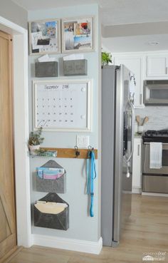 a kitchen with a refrigerator and pictures hanging on the wall above it's door