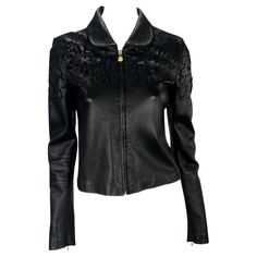 Presenting a sleek black Gianni Versace leather jacket designed by Donatella Versace. This collared leather jacket features a flat, rounded collar, cut floral design, and Medusa logo zipper pulls. The unique floral cut-out details on the coat have a layer of black mesh under the leather, maintaining the dark look. Approximate measurements: Size - 40IT Shoulder to hem: 20” Bust: 32” Waist: 30” Shoulder to cuff: 25" Underarm to cuff: 19" Spring Long Sleeve Leather Jacket For Evening, Spring Evening Leather Jacket, Designer Long Sleeve Leather Jacket For Spring, Luxury Fitted Biker Jacket For Spring, Spring Evening Biker Jacket With Long Sleeves, Designer Leather Jacket For Party, Versace Leather Jacket, Versace Leather, Vintage Designer Bags