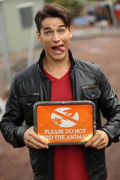 a man holding a sign that says please do not feed the animals