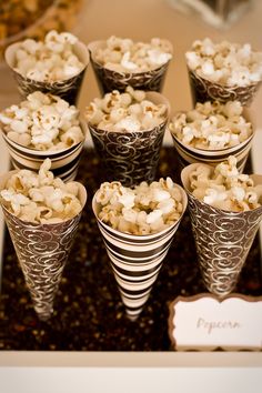 a bunch of cups filled with popcorn sitting on top of a table