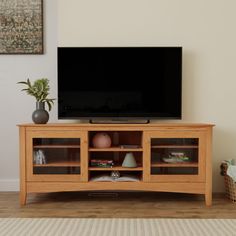 a flat screen tv sitting on top of a wooden entertainment center in a living room