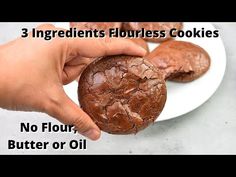 someone is holding a chocolate cookie on a white plate with the words 3 ingredients flourless cookies no flour, butter or oil