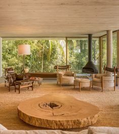 a living room with couches, chairs and a fire place in front of a large window