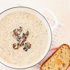 a bowl of oatmeal next to a piece of bread