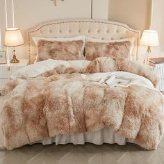 the bed is made with white and brown furs on it's comforter