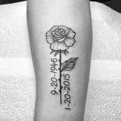 a black and white photo of a rose with the date on it's arm