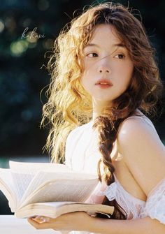 a girl with long hair is reading a book