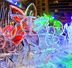 colorful glass figurines are displayed in front of a large building at night time