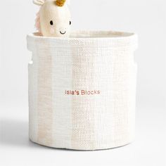 a stuffed animal in a white basket with pink writing on the front and bottom that says, salsa's blocks