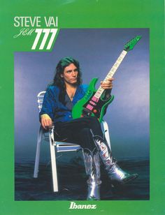 steve vai with his green guitar sitting on a chair in front of the ocean