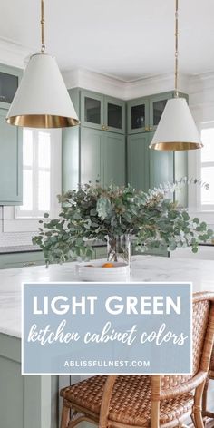 a kitchen with green cabinets and two pendant lights over the island in front of it