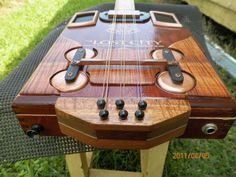 a wooden guitar sitting on top of a table