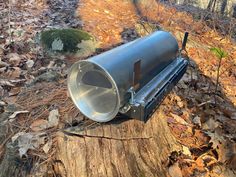 a large metal object sitting on top of a tree stump in the middle of a forest