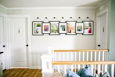 there are pictures hanging on the wall above the bed and below the bannister