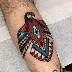 a man's arm with an eagle tattoo on it, which has geometric designs