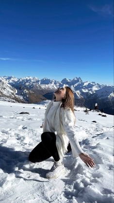 a woman standing on top of a snow covered slope