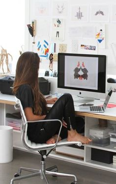 a woman sitting in front of a computer on top of a desk