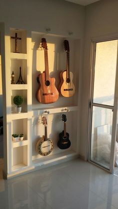 there are many guitars on the shelves in this room, and one is hanging from the wall