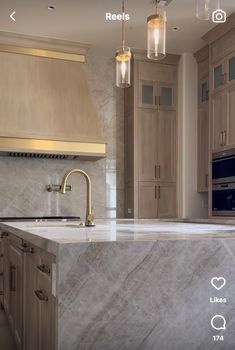 a kitchen with marble counter tops and wooden cabinets in the background, including a gold faucet