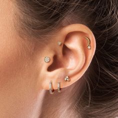 a woman wearing three different ear piercings