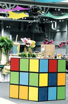 a colorful display in the middle of a room with lots of plants and decorations hanging from the ceiling