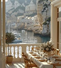 an outdoor dining area with tables and chairs overlooking the water