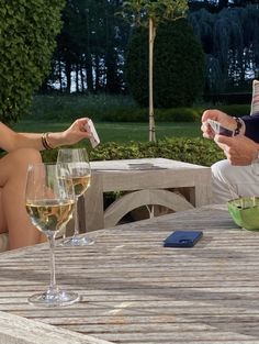 a man and woman sitting at a table with wine glasses in front of each other