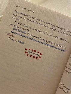 an open book with red hearts on it